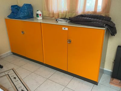 une armoire jaune dans un coin de la pièce, près d'une fenêtre