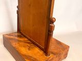 an image of a small wooden mirror on a stand on a white background
