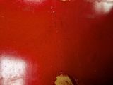 a close up of a red vase with yellow dots on it