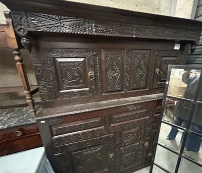 un grand coffre en bois posé dans une pièce où se trouve un miroir