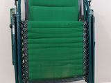 une chaise de jardin verte posée sur une table blanche