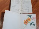 an open book sitting on top of a wooden table next to a piece of paper
