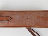 an image of a brown leather case with a long strap