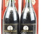 deux bouteilles de vin posées l'une à côté de l'autre devant une boîte rouge