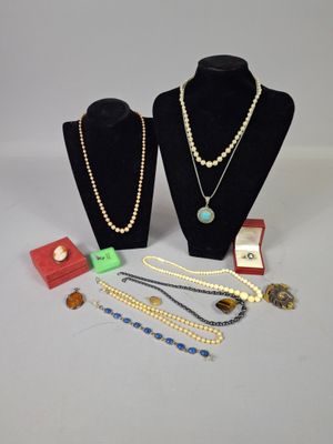 two necklaces and a ring on display on a table