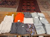 Plusieurs paires de pantalons pour homme sont disposées sur une table en bois