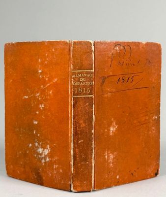 un vieux livre posé sur une table blanche à côté d'un mur blanc