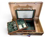 une valise ouverte contenant une montre et d'autres objets