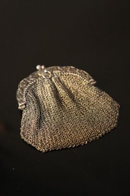 un gros plan d'un sac à main argenté posé sur une surface noire