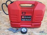 an image of a red air compressor sitting on top of a wooden floor