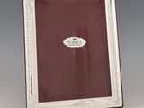 an antique silver plated picture frame with a red background