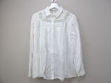 white blouse with lace trim and long sleeves on hanger
