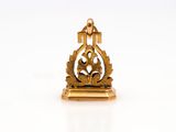 a small gold figurine with a cross on top of it