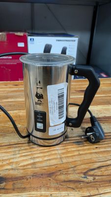 une cafetière avec une anse posée sur une table en bois