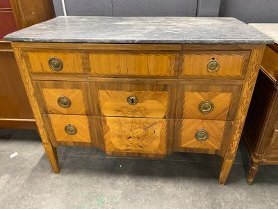 a wooden dresser with marble top in a room