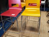 plusieurs chaises de différentes couleurs dans une pièce, avec une télévision en arrière-plan