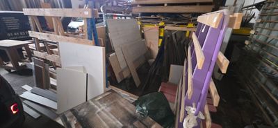 plusieurs pièces de bois sont empilées sur des palettes dans un entrepôt