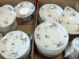 many plates and cups in a box on the table