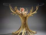 a glass table with gold branches and a glass top