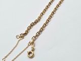 a pair of gold chain necklaces on a white surface