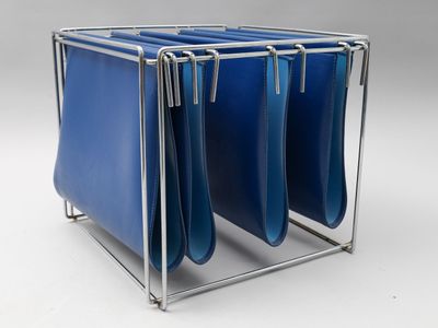 une étagère métallique sur laquelle sont posés quatre sacs bleus