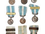 an assortment of medals and medals are displayed on a white surface
