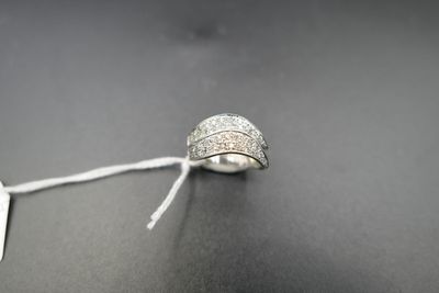 une image représentant une bague en argent posée sur une surface noire, accompagnée d'une étiquette