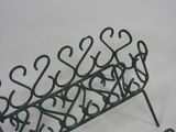 a green metal bench with hearts on it on a white surface