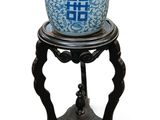 un vase bleu et blanc posé sur un petit socle