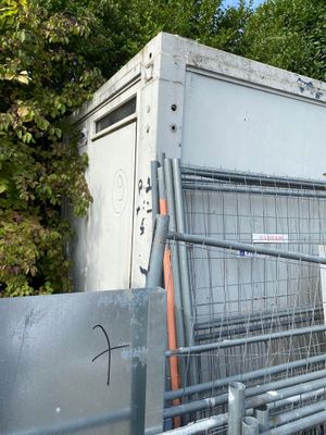 a metal gate with a sign on it next to a fence