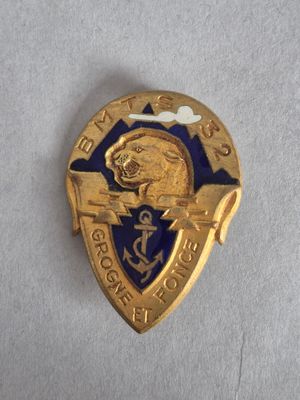 un gros plan d'un insigne doré et bleu sur une surface blanche