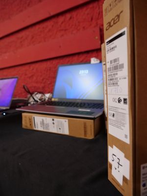 deux ordinateurs portables posés sur une table devant un mur rouge