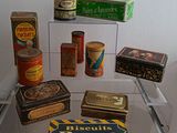 many different types of tins on display in a glass case