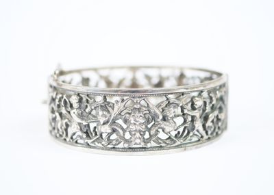 gros plan d'un bracelet en argent sur une surface blanche