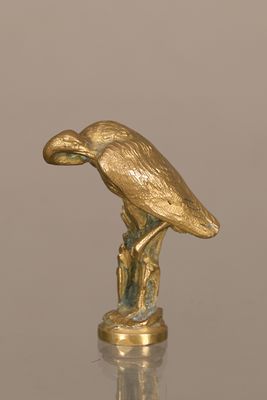 une statue en or représentant un oiseau perché sur une souche d'arbre