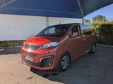 Une voiture rouge est garée sous un auvent bleu et blanc.