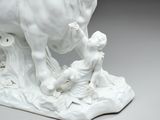 a statue of a cow and a child on the ground