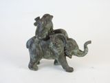 a statue of an elephant that is sitting on top of another elephant