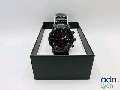 a close up of a watch in a box on a white surface
