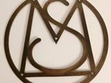 a close up of a metal sign with the letter a in a circle