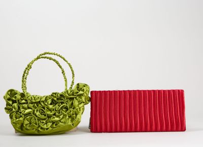 un sac à main vert et rouge à côté d'un porte-monnaie rouge sur fond blanc
