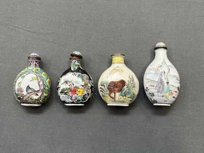 quatre petits vases aux motifs variés, posés sur une table