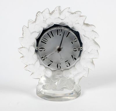 une horloge blanche posée sur un socle en verre