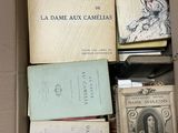 de nombreux livres dans une boîte, posés sur une table