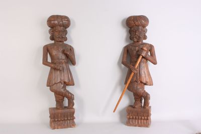 paire de figurines en bois sculpté représentant un homme et une femme, l'un muni d'une canne
