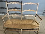 a wooden bench with a wicker seat on it