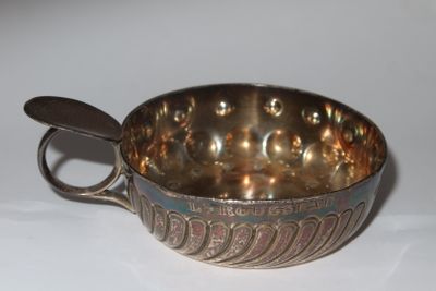 a silver bowl with a spoon in it on a table
