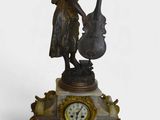 une statue représentant une femme jouant d'un instrument de musique posée sur une table