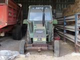 a tractor that is parked in a barn with hay