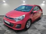 une voiture rouge est garée dans une pièce au sol en damier